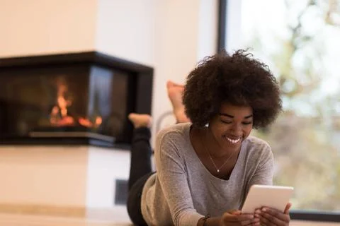 Black women using tablet computer on the floor beautiful young black women... Stock Photos