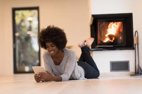 Black women using tablet computer on the floor beautiful young black women... Stock Photos