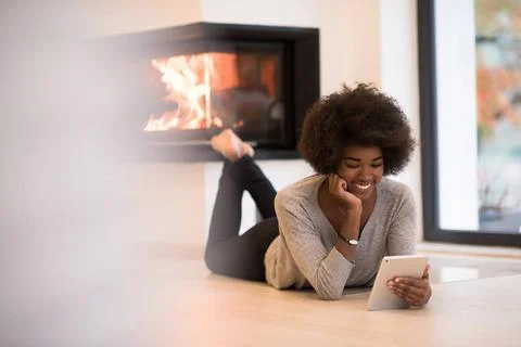 Black women using tablet computer on the floor beautiful young black women... Stock Photos