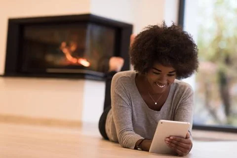 Black women using tablet computer on the floor beautiful young black women... Stock Photos