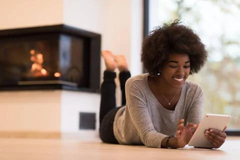 Black women using tablet computer on the floor beautiful young black women... Stock Photos