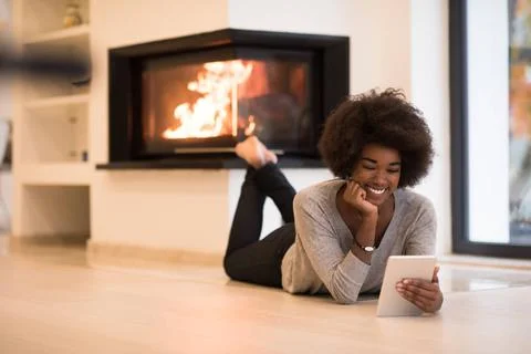Black women using tablet computer on the floor beautiful young black women... Stock Photos