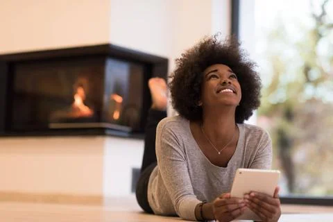 Black women using tablet computer on the floor beautiful young black women... Stock Photos