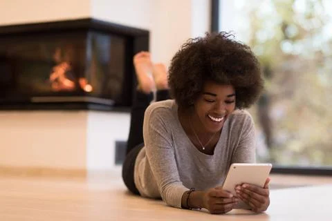 Black women using tablet computer on the floor beautiful young black women... Stock Photos