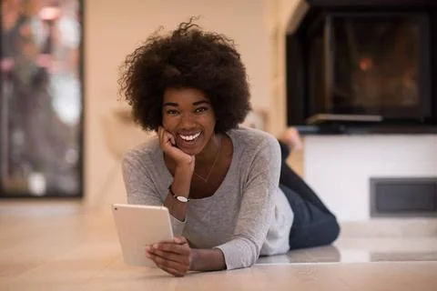 Black women using tablet computer on the floor beautiful young black women... Stock Photos