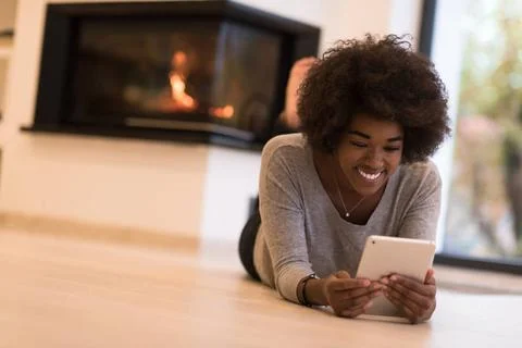 Black women using tablet computer on the floor beautiful young black women... Stock Photos