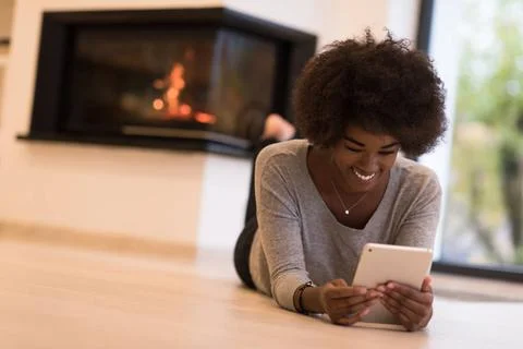 Black women using tablet computer on the floor beautiful young black women... Stock Photos