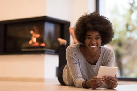 Black women using tablet computer on the floor beautiful young black women... Stock Photos