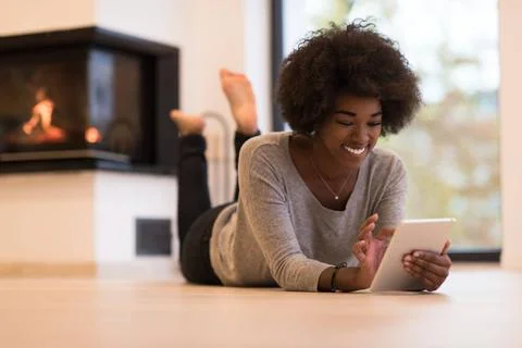 Black women using tablet computer on the floor beautiful young black women... Stock Photos