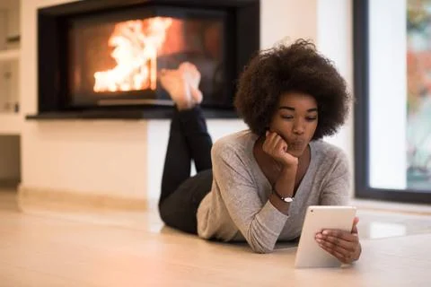 Black women using tablet computer on the floor beautiful young black women... Stock Photos