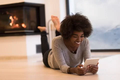 Black women using tablet computer on the floor beautiful young black women... Stock Photos