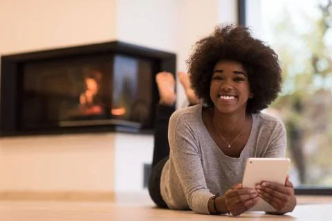 Black women using tablet computer on the floor beautiful young black women... Stock Photos