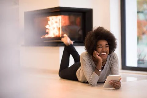 Black women using tablet computer on the floor beautiful young black women... Stock Photos