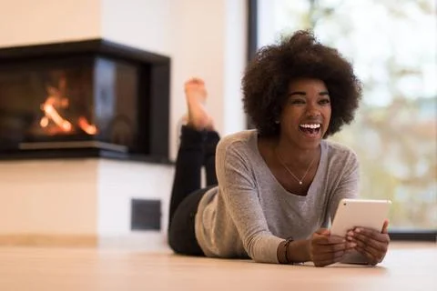 Black women using tablet computer on the floor beautiful young black women... Stock Photos