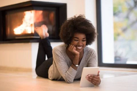 Black women using tablet computer on the floor beautiful young black women... Stock Photos