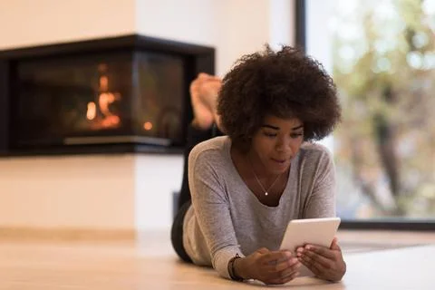 Black women using tablet computer on the floor beautiful young black women... Stock Photos