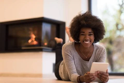 Black women using tablet computer on the floor beautiful young black women... Stock Photos