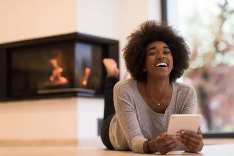 Black women using tablet computer on the floor beautiful young black women... Stock Photos