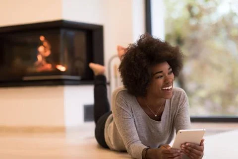 Black women using tablet computer on the floor beautiful young black women... Stock Photos