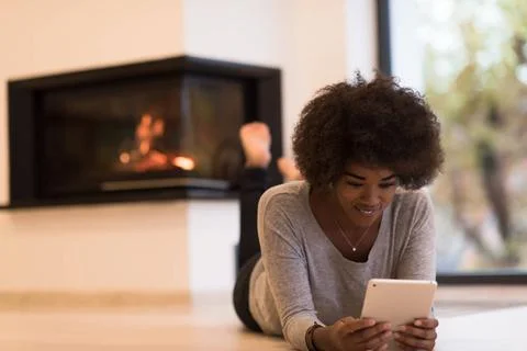 Black women using tablet computer on the floor beautiful young black women... Stock Photos