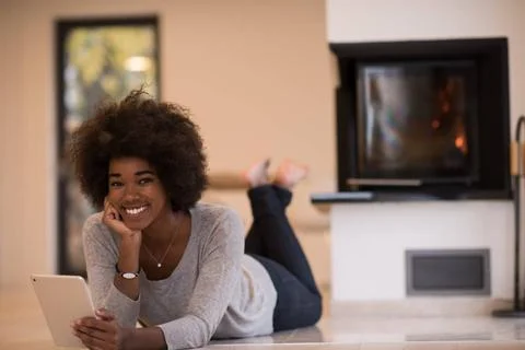 Black women using tablet computer on the floor beautiful young black women... Stock Photos