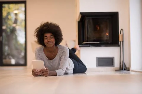 Black women using tablet computer on the floor beautiful young black women... Stock Photos