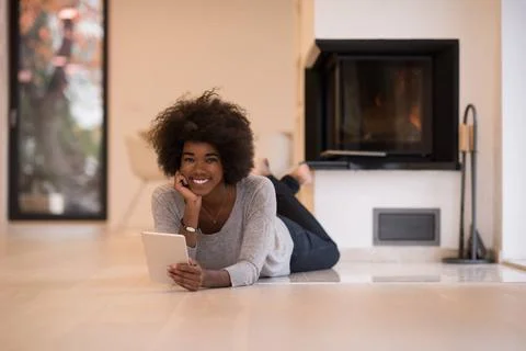 Black women using tablet computer on the floor beautiful young black women... Stock Photos