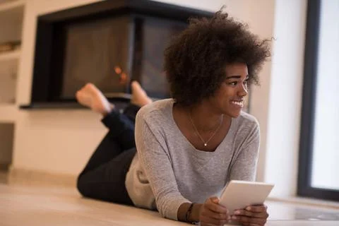 Black women using tablet computer on the floor beautiful young black women... Stock Photos