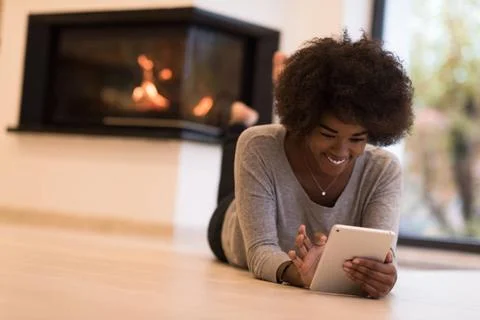 Black women using tablet computer on the floor beautiful young black women... Stock Photos