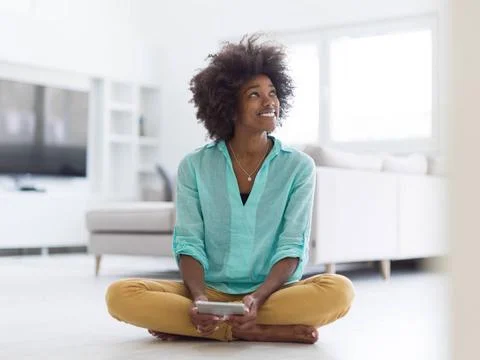 Black women using tablet computer on the floor at home beautiful young bla... Stock Photos