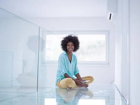 Black women using tablet computer on the floor at home beautiful young bla... Stock Photos
