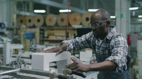 Black Worker Adjusting Clamps on Machinery in Commercial Printing House Stock Footage 335485239