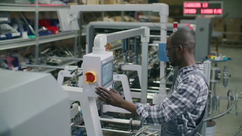 Black Worker Operating Automated Machine Console in Printing Factory Stock Footage 335486045