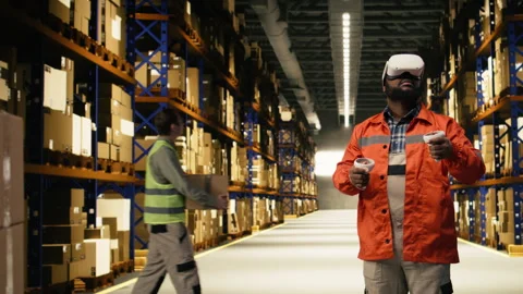 Black worker practices parcel scanning in VR environment with headset Stock Footage 332907350