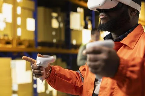 Black worker practices parcel scanning in VR environment with headset Fotos de archivo