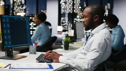 Black worker uses AI chatbot system at desktop for problem solving tasks Stock Footage 318500473