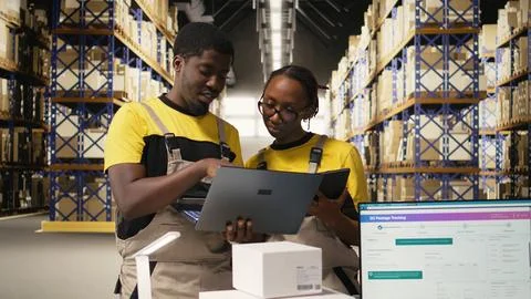 Black workers team preparing merchandise for dispatch in large warehouse 스톡 사진
