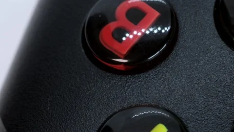 Black xbox controller macro shot, white background surface rotating motion Stock Footage 183844961