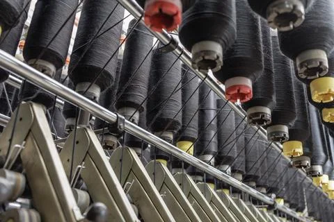 Black yarn cones on spinning machine in textile factory close up Stock Photos
