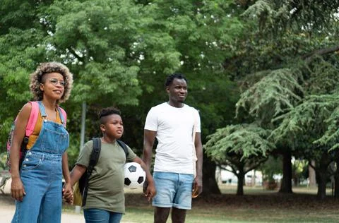 Black young family in a park after school. African American Mother and father Stock Photos
