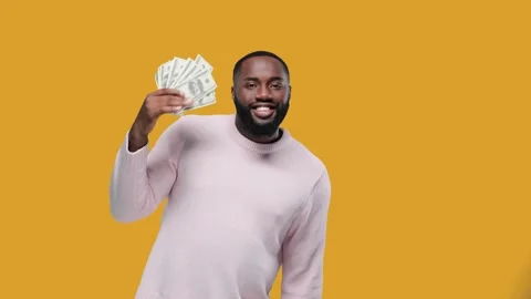 Black young funny man dancing with dollars on yellow background Stock Footage 142795979