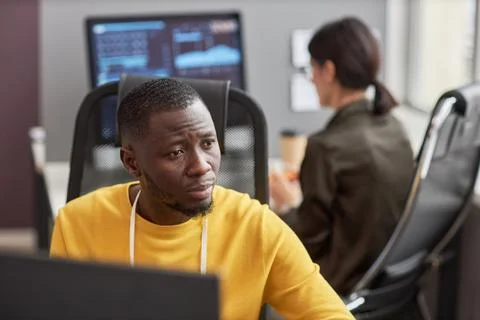 Black young man as software developer using computer at workplace in office Foto stock
