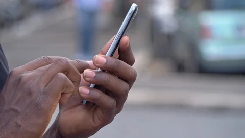 Black young man's hands typing on smartphone in the street Vídeo Stock 92779754
