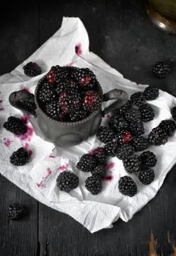 Blackberries on white napkin in rustic setting Stock Photos