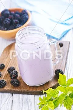 Blackberry yogurt in glass on a table Stock Photos