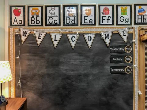 Blackboard in elementary school classroom with welcome banner and alphabet Stock Photos