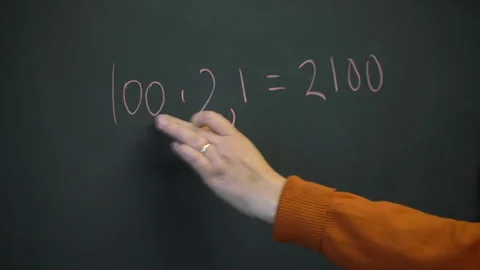 A blackboard with a math formula, a magnet and a moving  hand of a teacher  Stock Footage 236119185