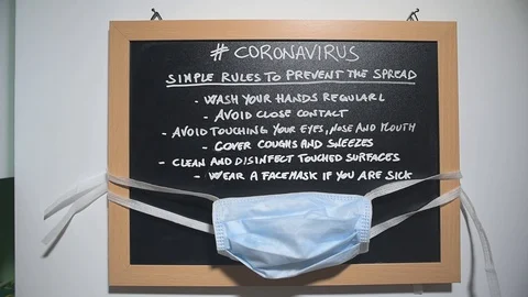 Blackboard with rules to avoid the spread of Coronavirus and hanging safe mask Stock Footage 127018953