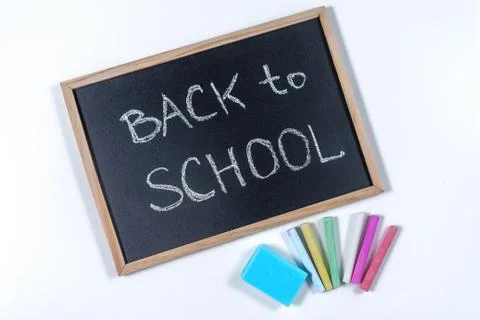 A blackboard with text Back to School, a set of colored crayons and a sponge on Stock Photos