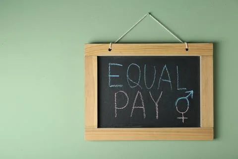 Blackboard with words Equal Pay and gender symbols hanging on light green w.. Stock Photos